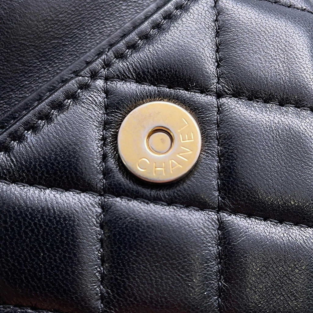 Close-up of MANSII Chanel used Ball Bag showcasing the signature gold button detail on quilted black leather