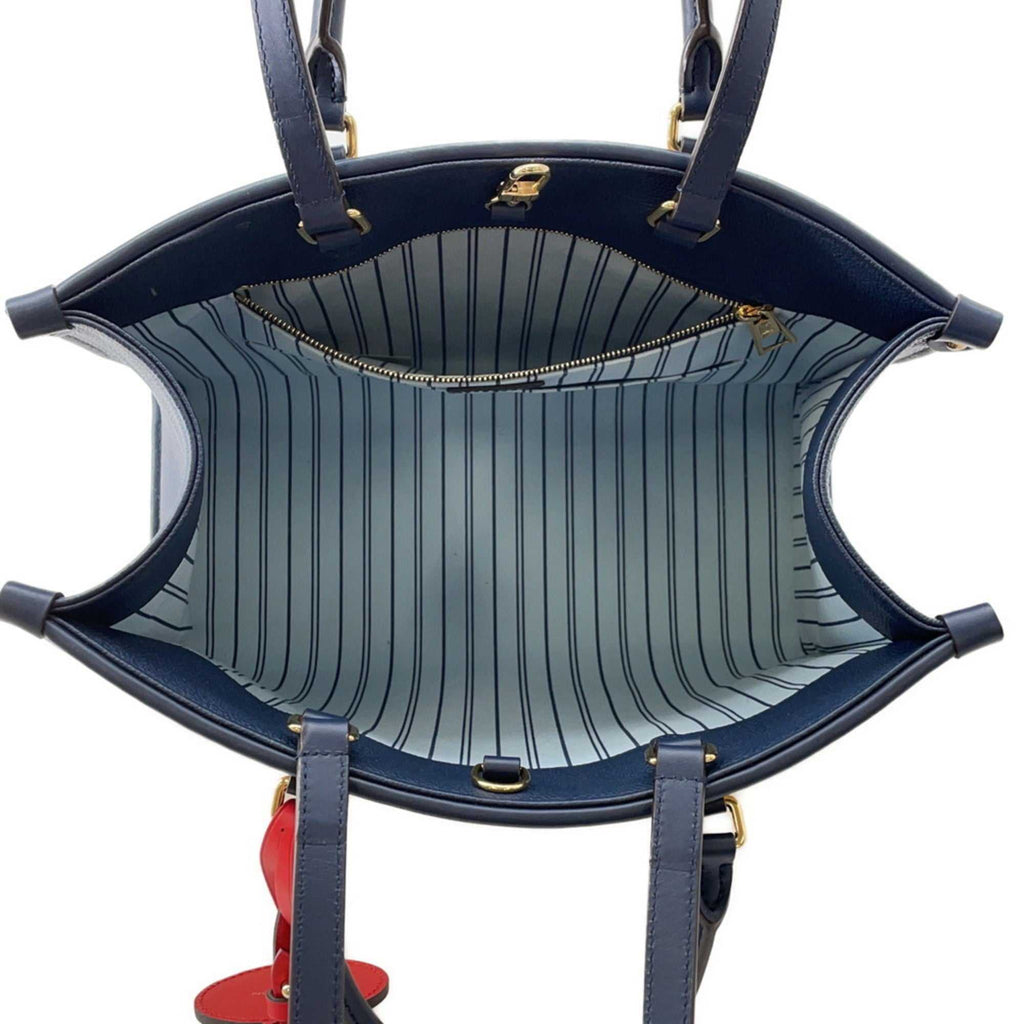 Interior view of the LOUIS VUITTON Pre-Loved Monogram Raffia On-the-Go tote bag featuring striped lining and zip pocket