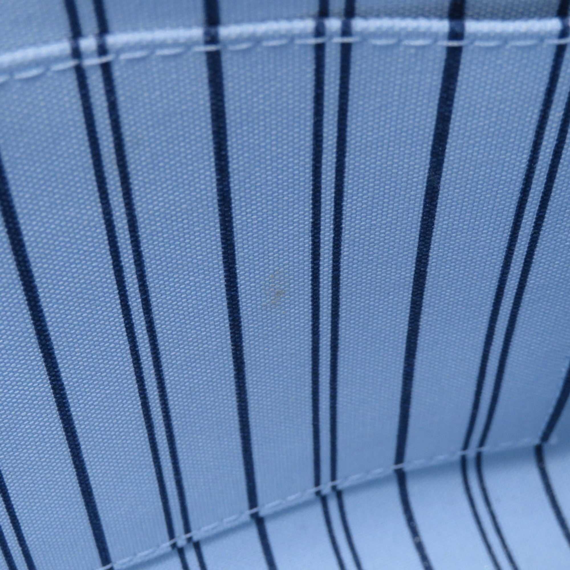 Interior view of LOUIS VUITTON Pre-Loved Monogram Raffia On-the-Go tote bag with blue striped lining