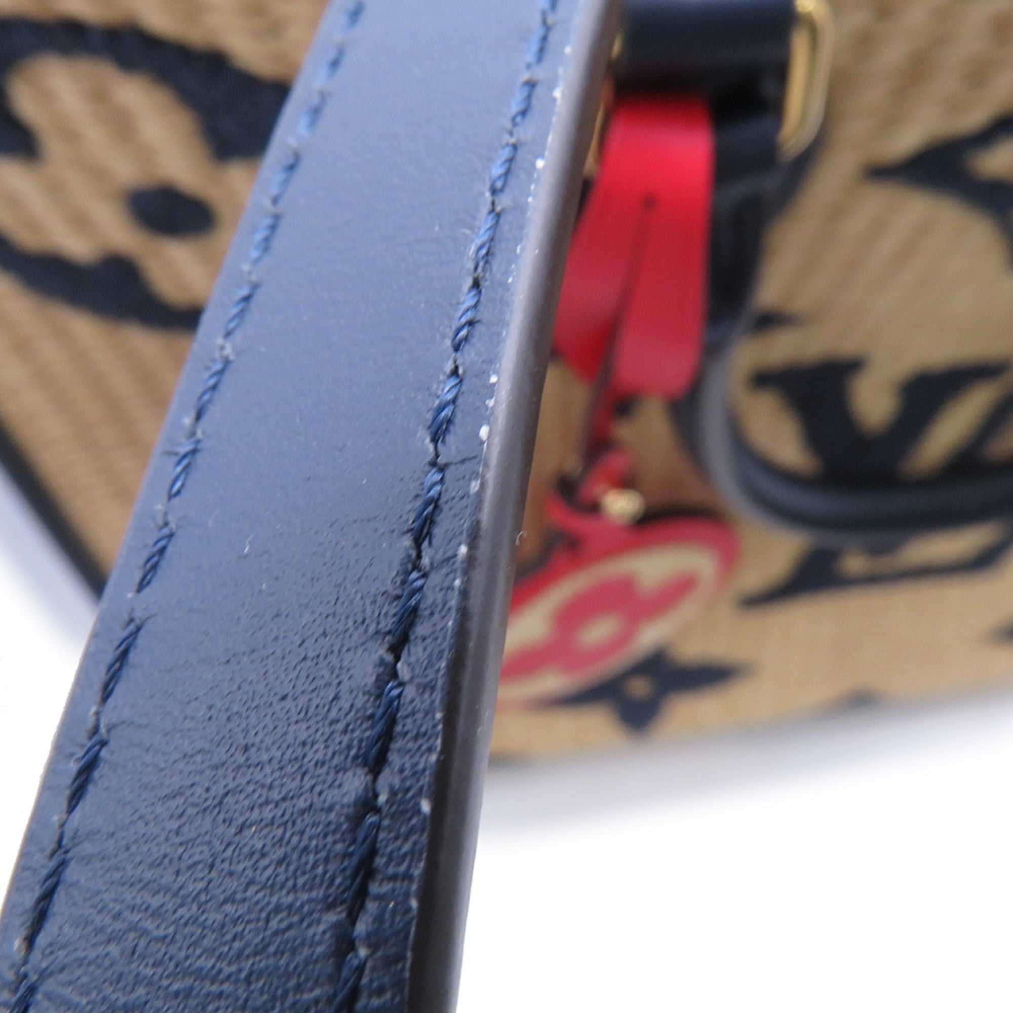 Close-up of LOUIS VUITTON Pre-Loved Monogram Raffia On-the-Go tote bag handle with detailed stitching