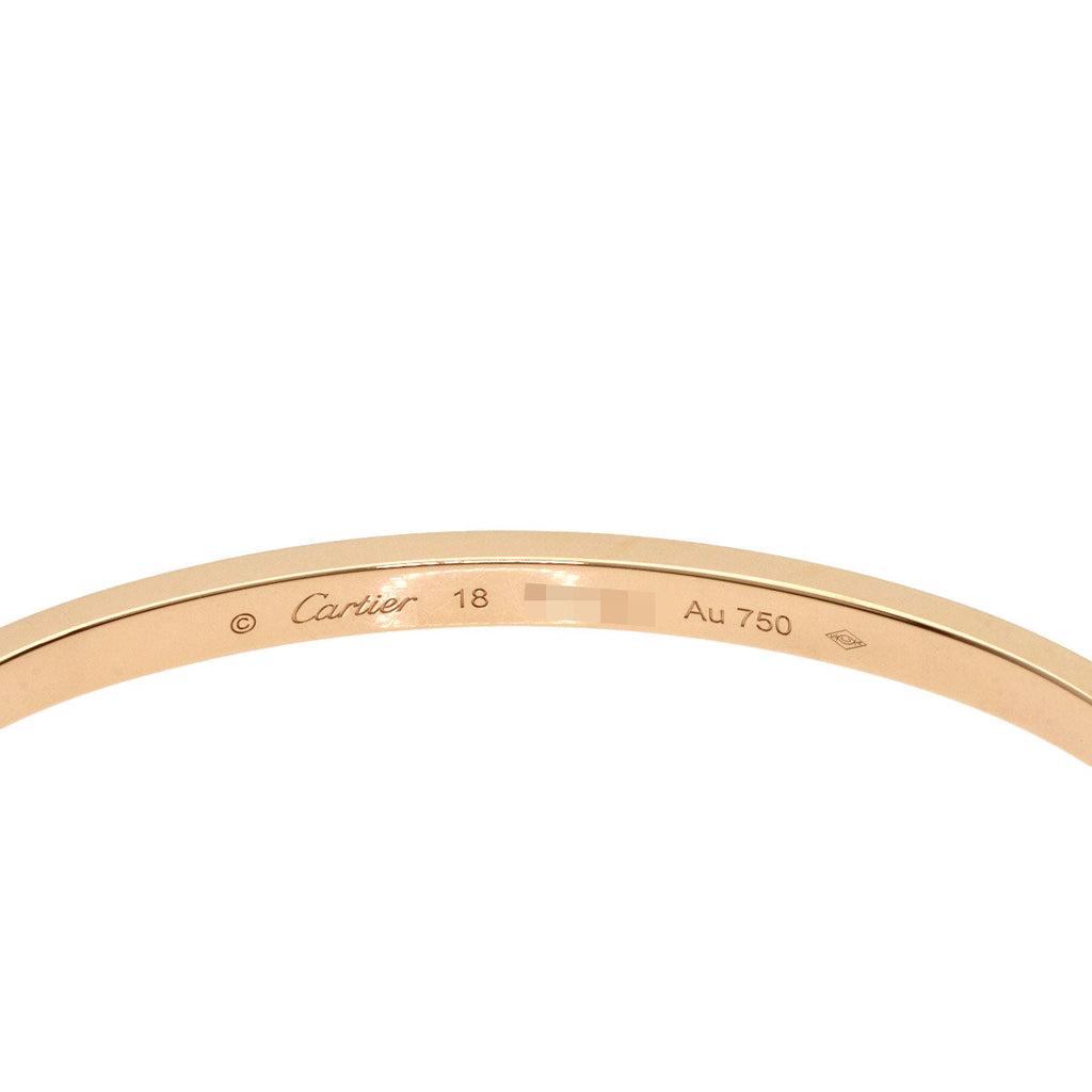 Close-up of a Cartier Love bracelet used, featuring a sleek gold design with signature engraving