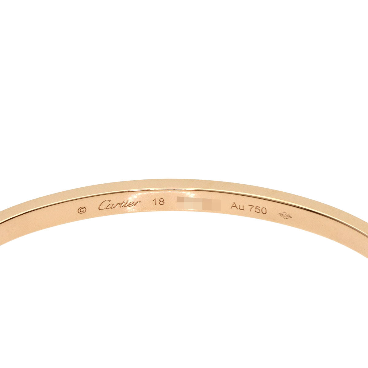 Close-up of a Cartier Love bracelet used, featuring a sleek gold design with signature engraving