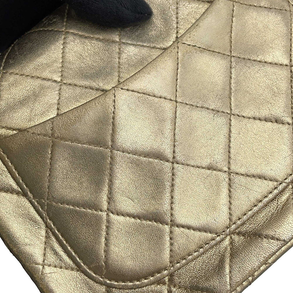 Close-up of authentic Chanel Matelasse 18 for sale featuring a luxurious quilted gold leather design