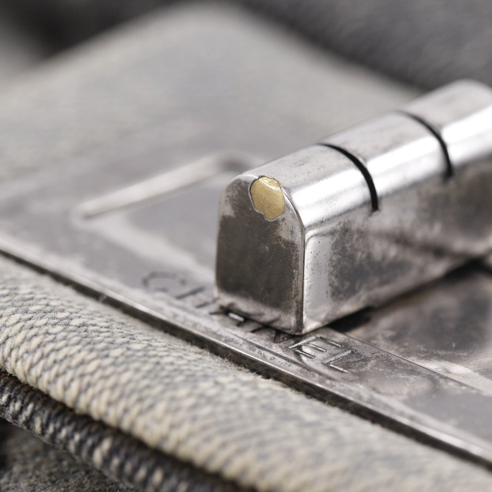 CHANEL bag detail showing metal clasp in fair condition with slight wear on the surface