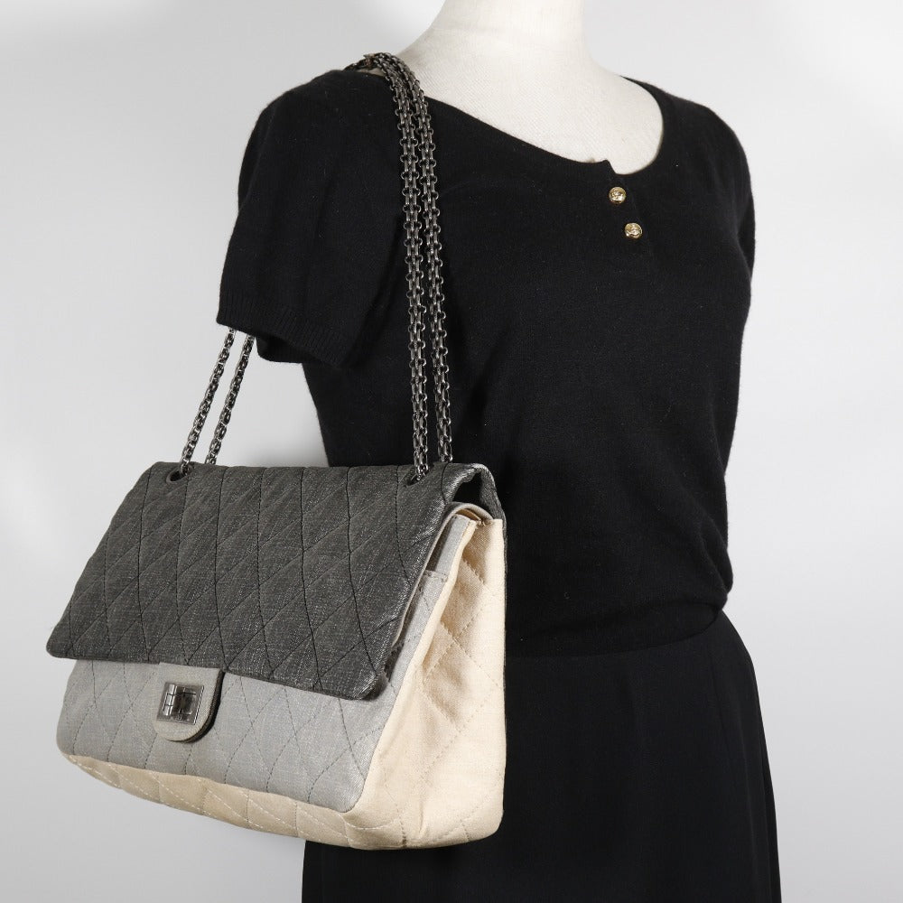 CHANEL quilted bag in fair condition with gray and cream colors featuring a stylish chain strap