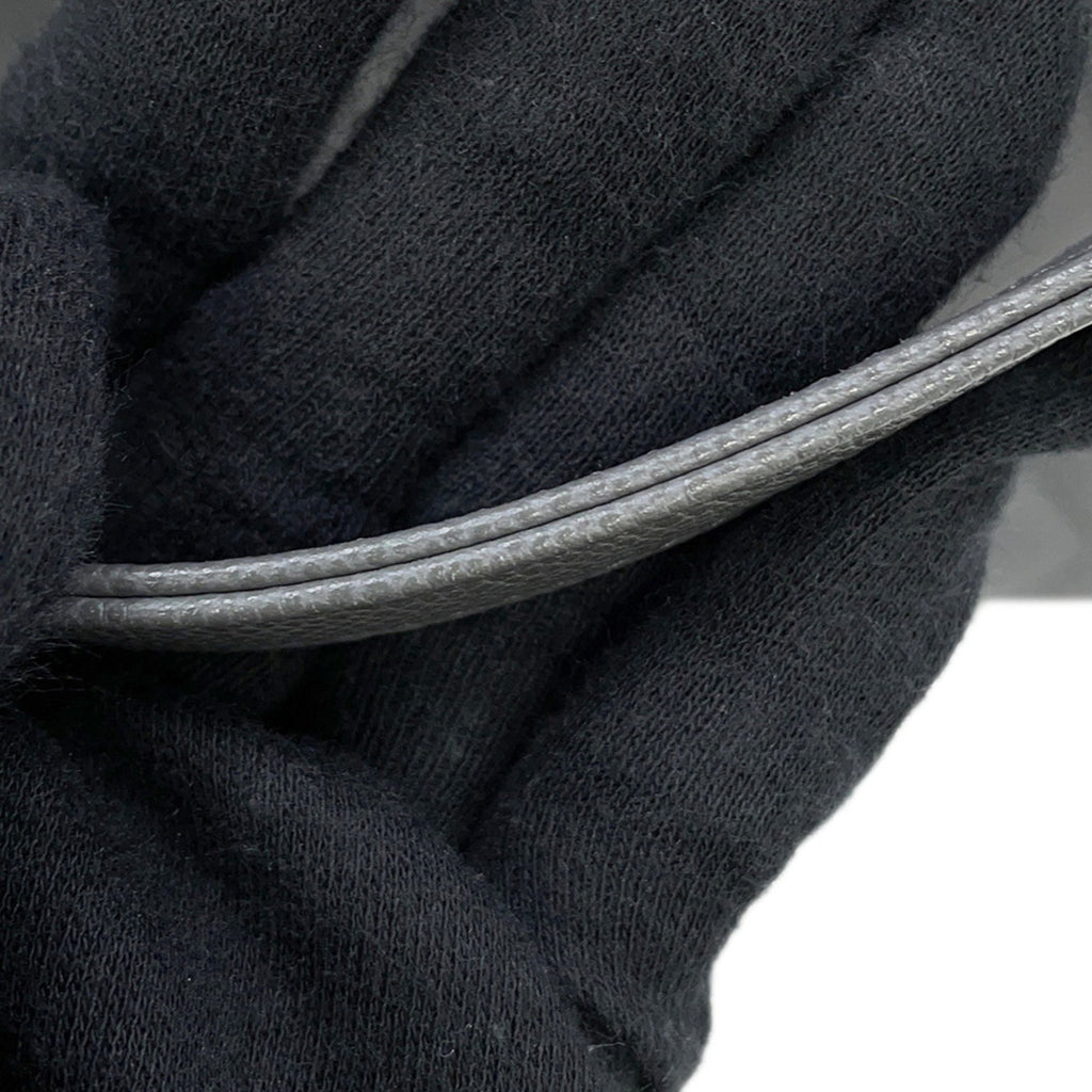 Close-up of the handle detailing on a luxury designer tote bag Chanel in elegant gray leather