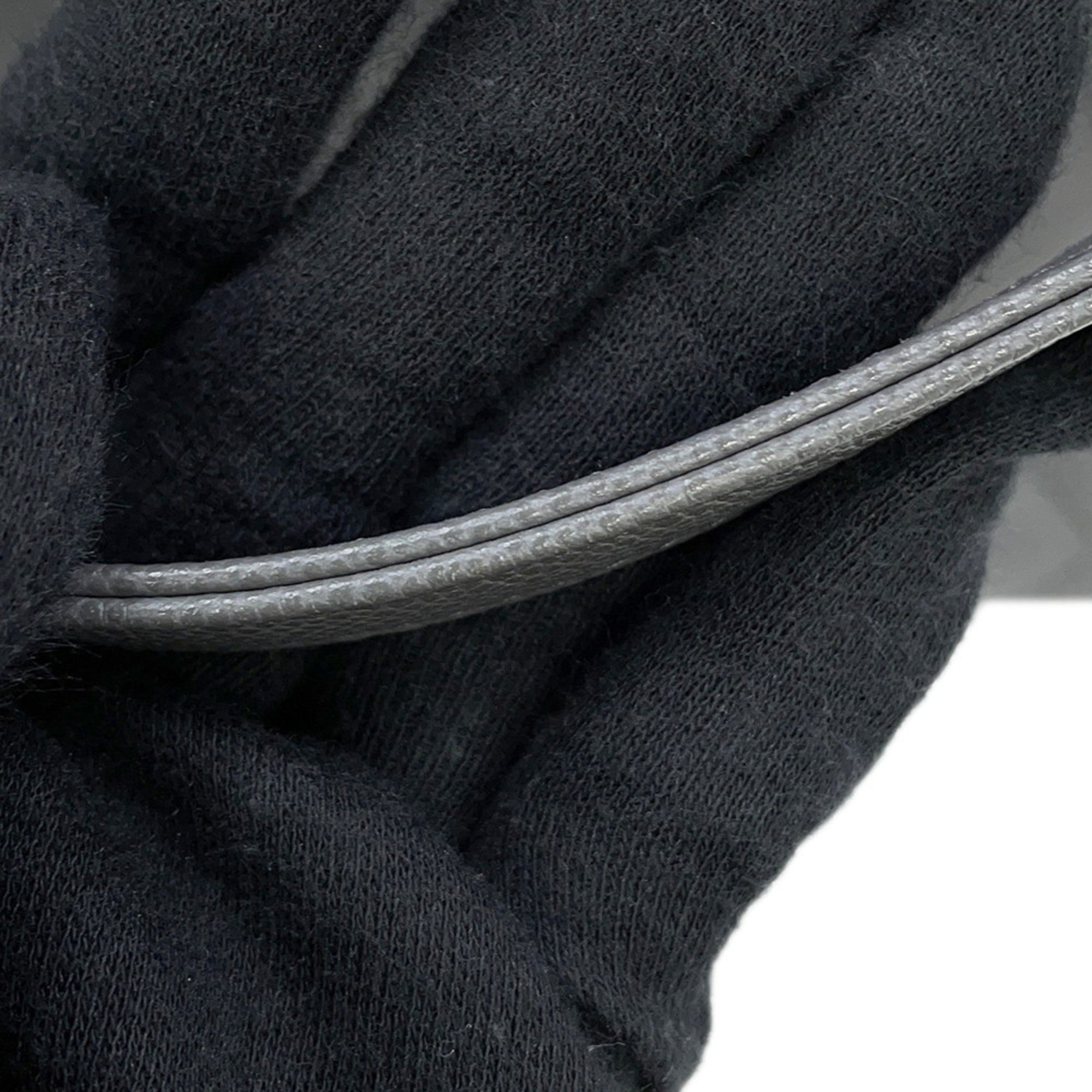 Close-up of the handle detailing on a luxury designer tote bag Chanel in elegant gray leather