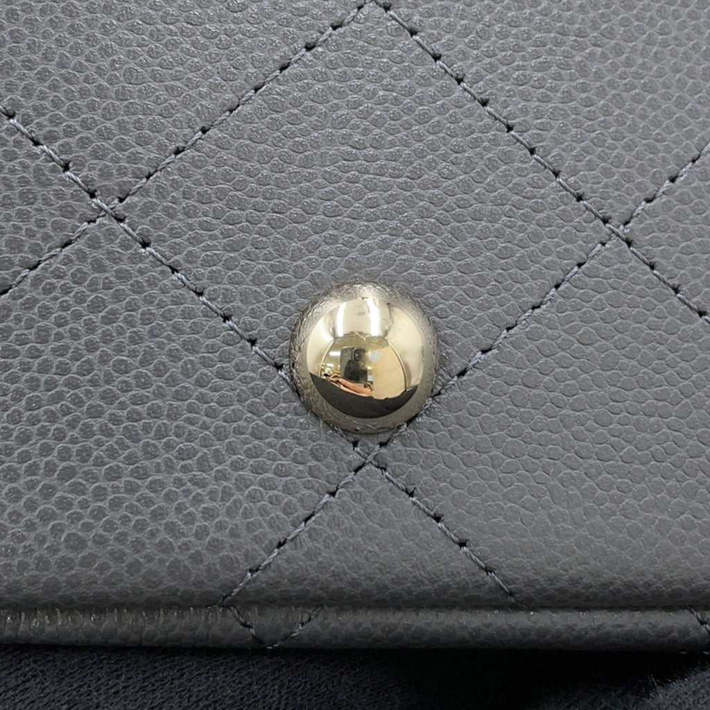 Close-up of a luxury designer tote bag Chanel showcasing the signature quilted texture and gold hardware