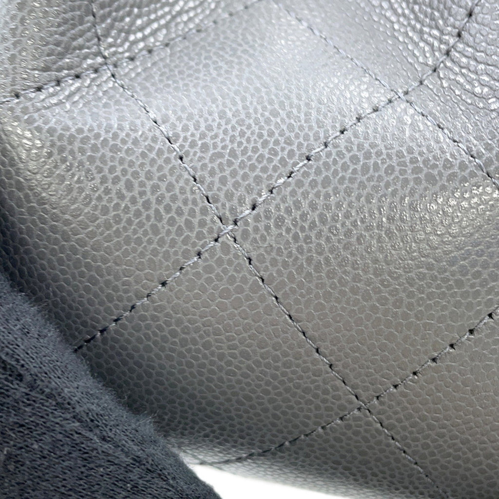 Close-up of the textured surface of a luxury designer tote bag Chanel in stylish gray leather