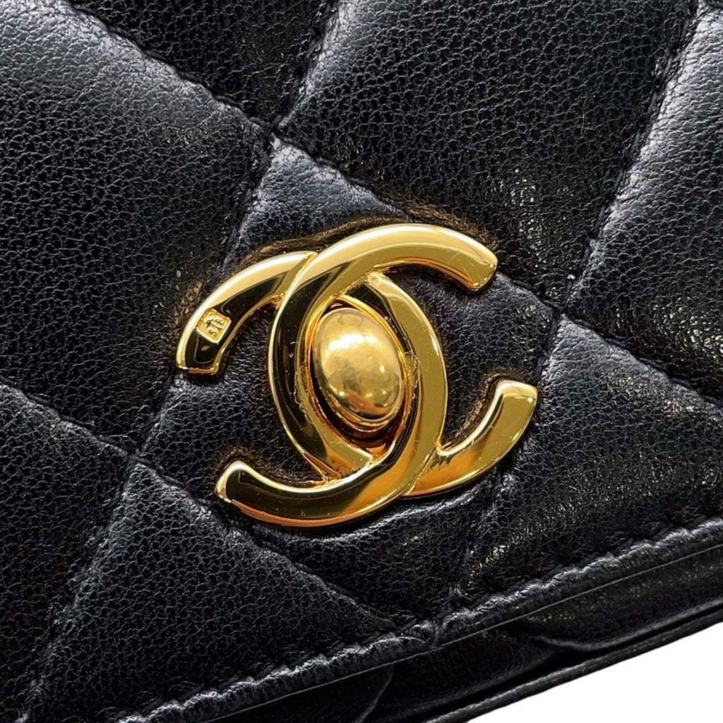 Close-up of the CHANEL Pre-Loved Matelasse Full Flap handbag featuring a gold CC logo and quilted leather design