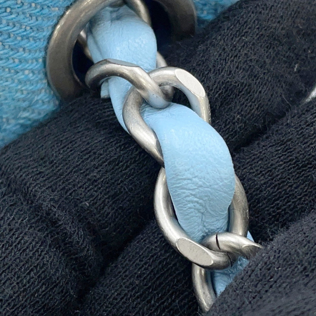 Close-up of the CHANEL Pre-Loved Mini Matelasse Denim bag featuring a light blue chain detail