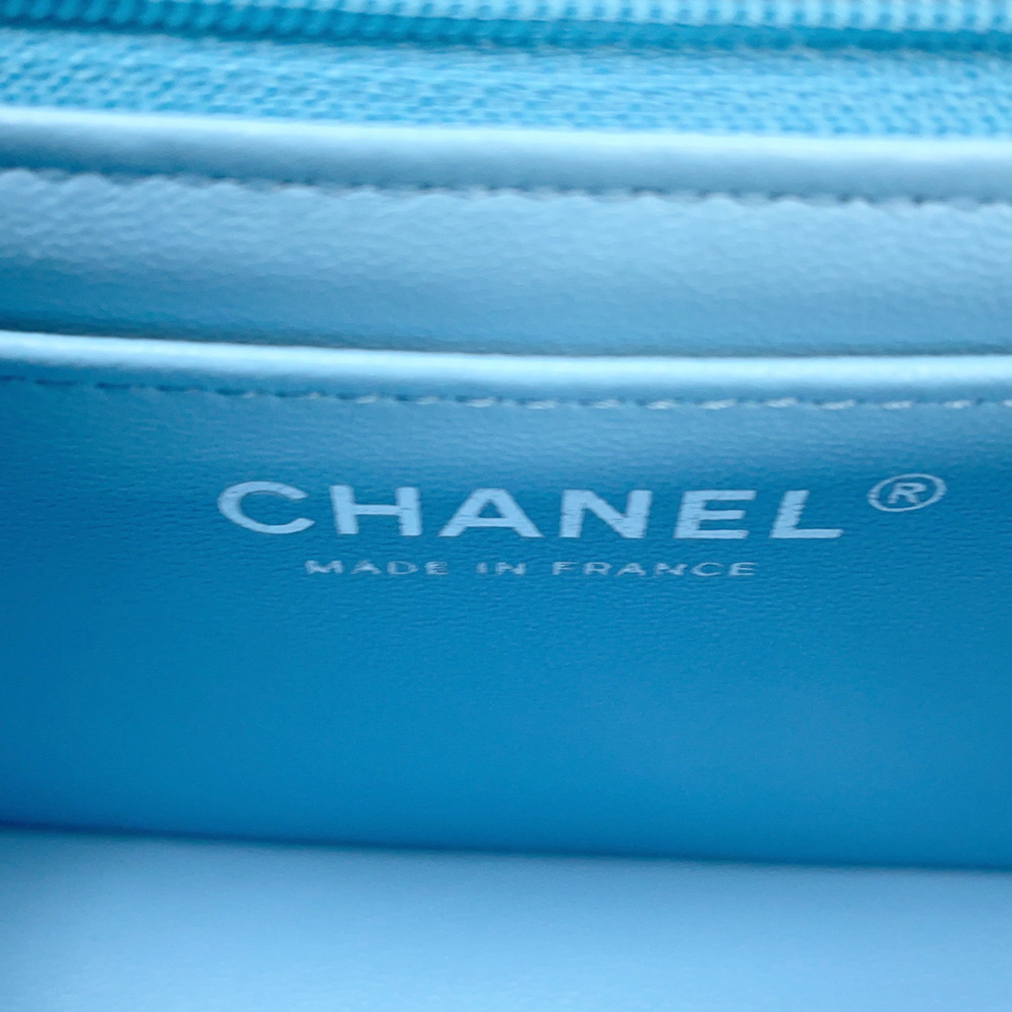 Inside view of a CHANEL Pre-Loved Mini Matelasse Denim handbag featuring the brand logo and soft lining