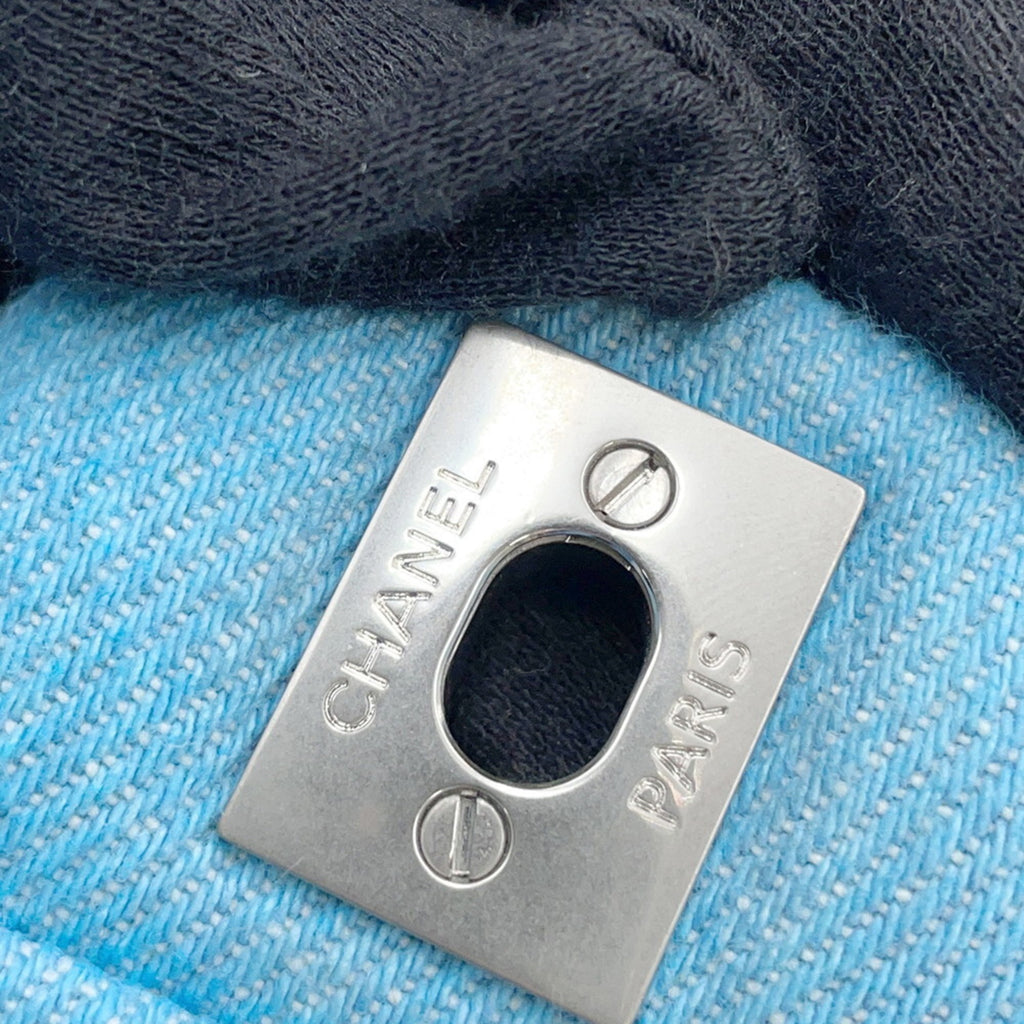 Close-up of CHANEL Pre-Loved Mini Matelasse Denim logo detailing on a blue denim bag