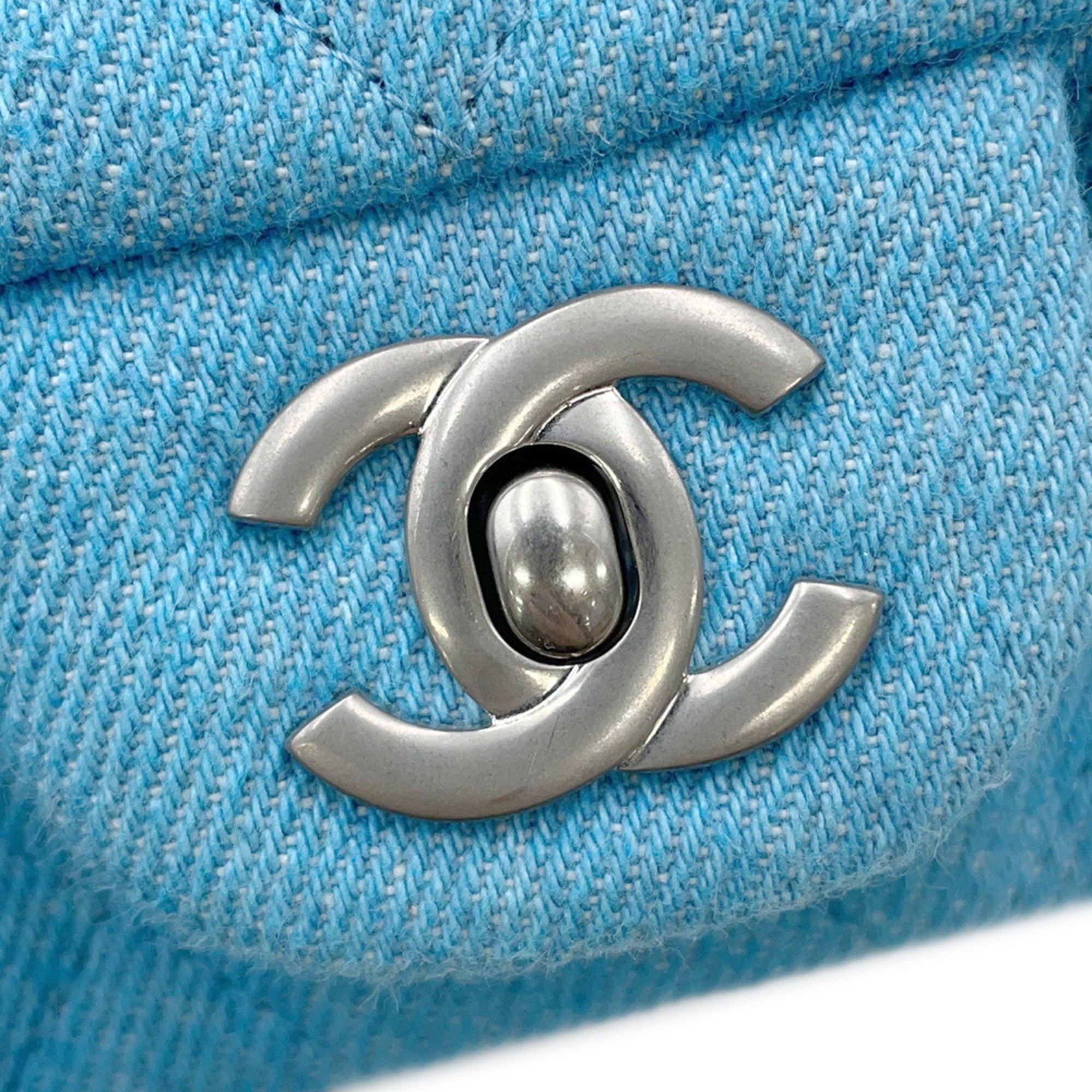 Close-up of CHANEL Pre-Loved Mini Matelasse Denim logo detail showcasing quality craftsmanship