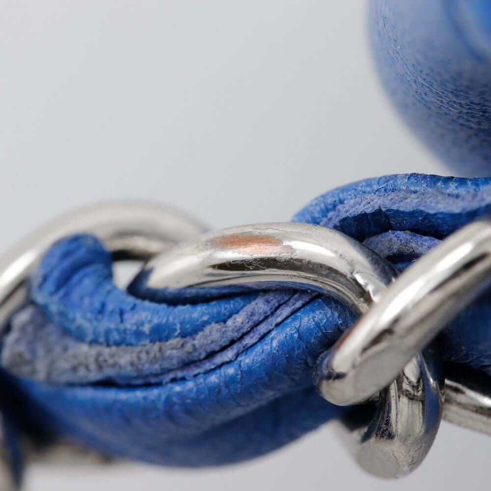 Close-up of a CHANEL pre-owned bag featuring a blue leather chain detail and metal hardware