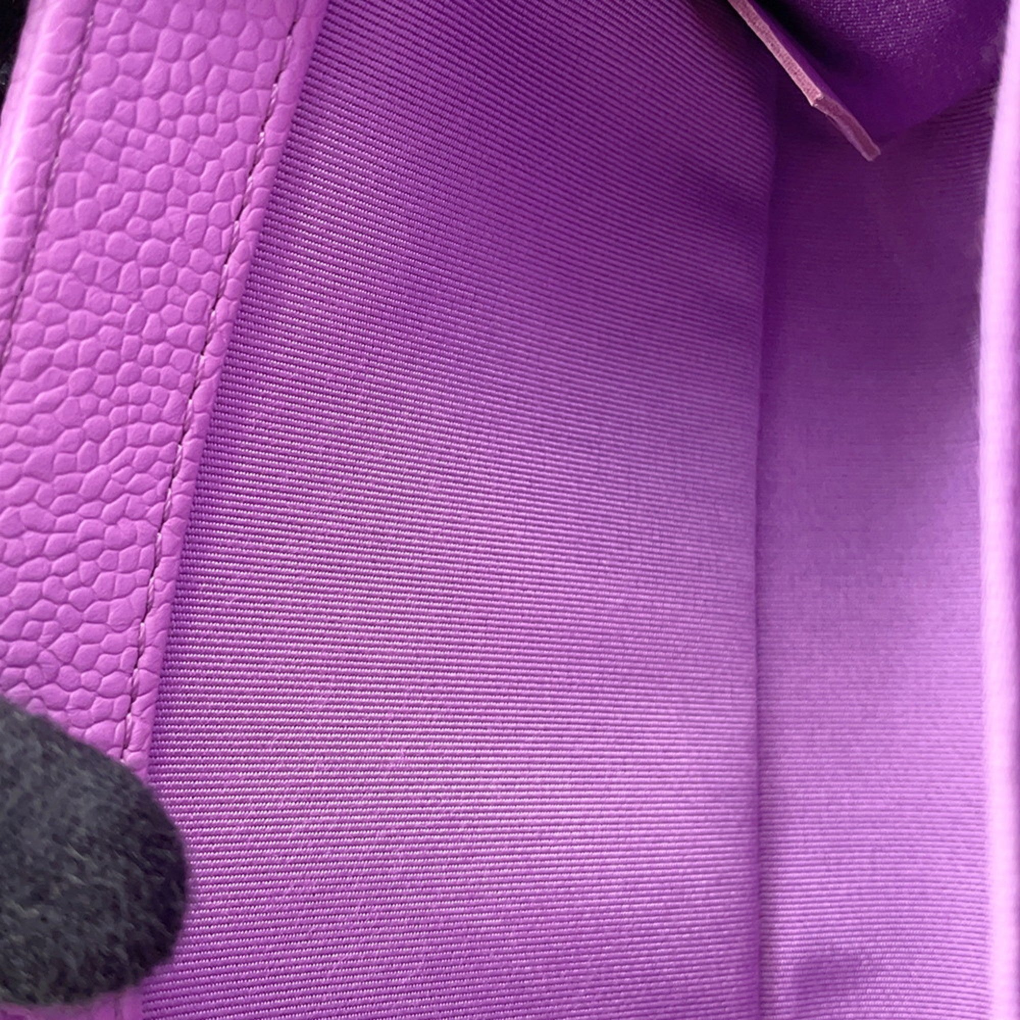 Interior view of a pre owned Chanel bag showcasing vibrant purple lining and textured material