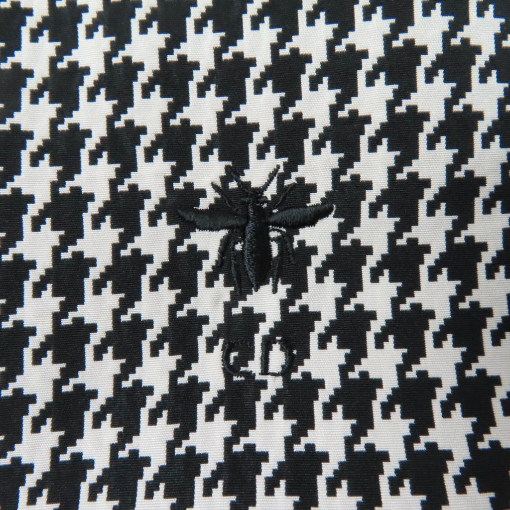 Close-up of Christian Dior pre-loved anorak fabric featuring a houndstooth pattern and embroidered bee design