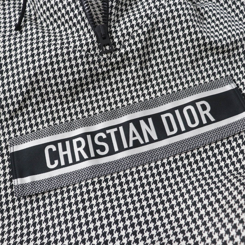 Close-up of Christian Dior pre-loved anorak featuring a bold logo and houndstooth pattern