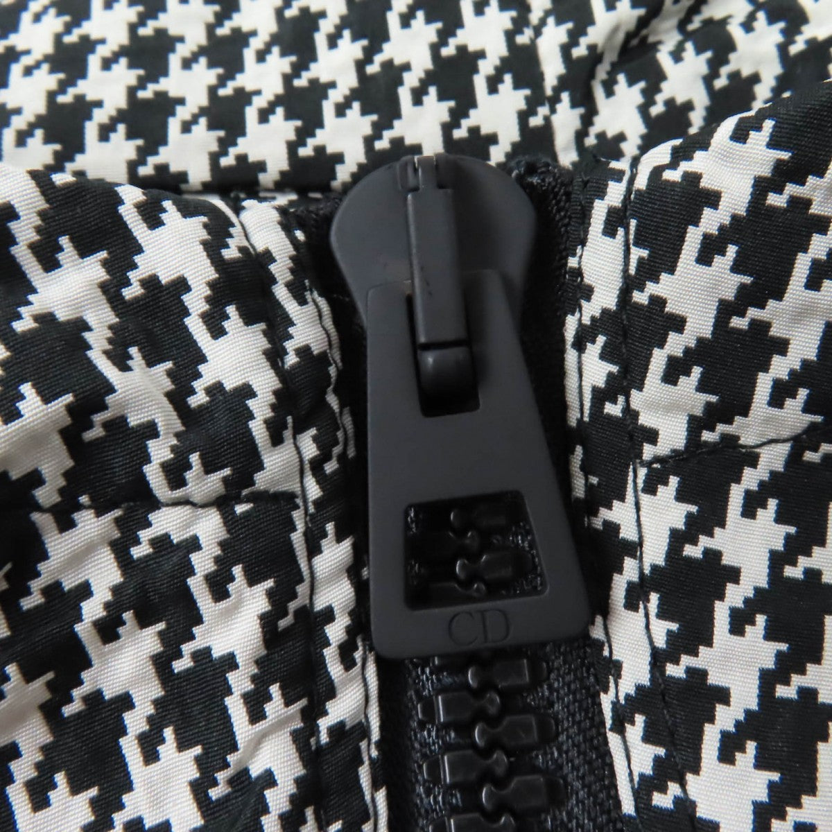 Close-up of the zipper detail on a Christian Dior pre-loved anorak in houndstooth pattern