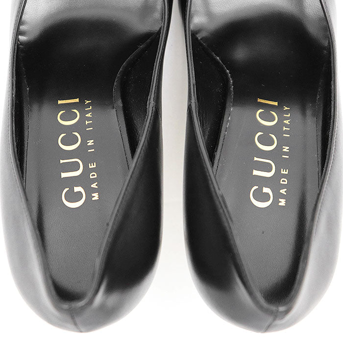 Top view of used Gucci Nero pumps online with sleek black leather finish and logo insole