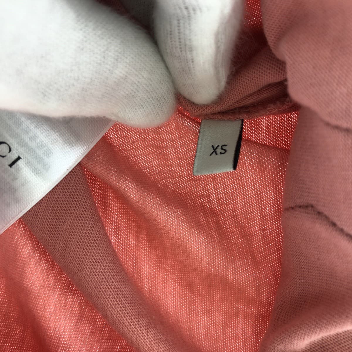 Tag showing size XS on a designer pre-loved Gucci shirt women in a soft coral color