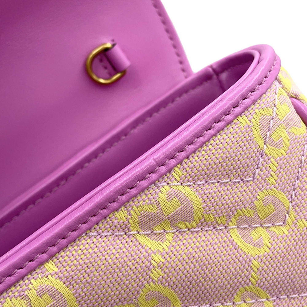 Interior view of GUCCI Pre-Loved GG Super Mini Canvas bag with vibrant pink lining and gold clasp detail