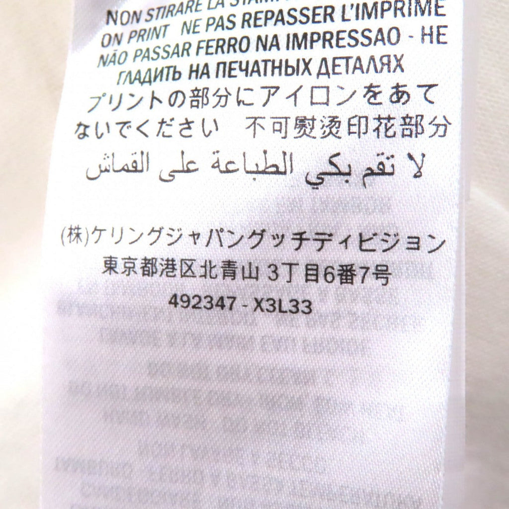 Pre-owned Gucci t-shirt tag showcasing care instructions and brand details on a white fabric