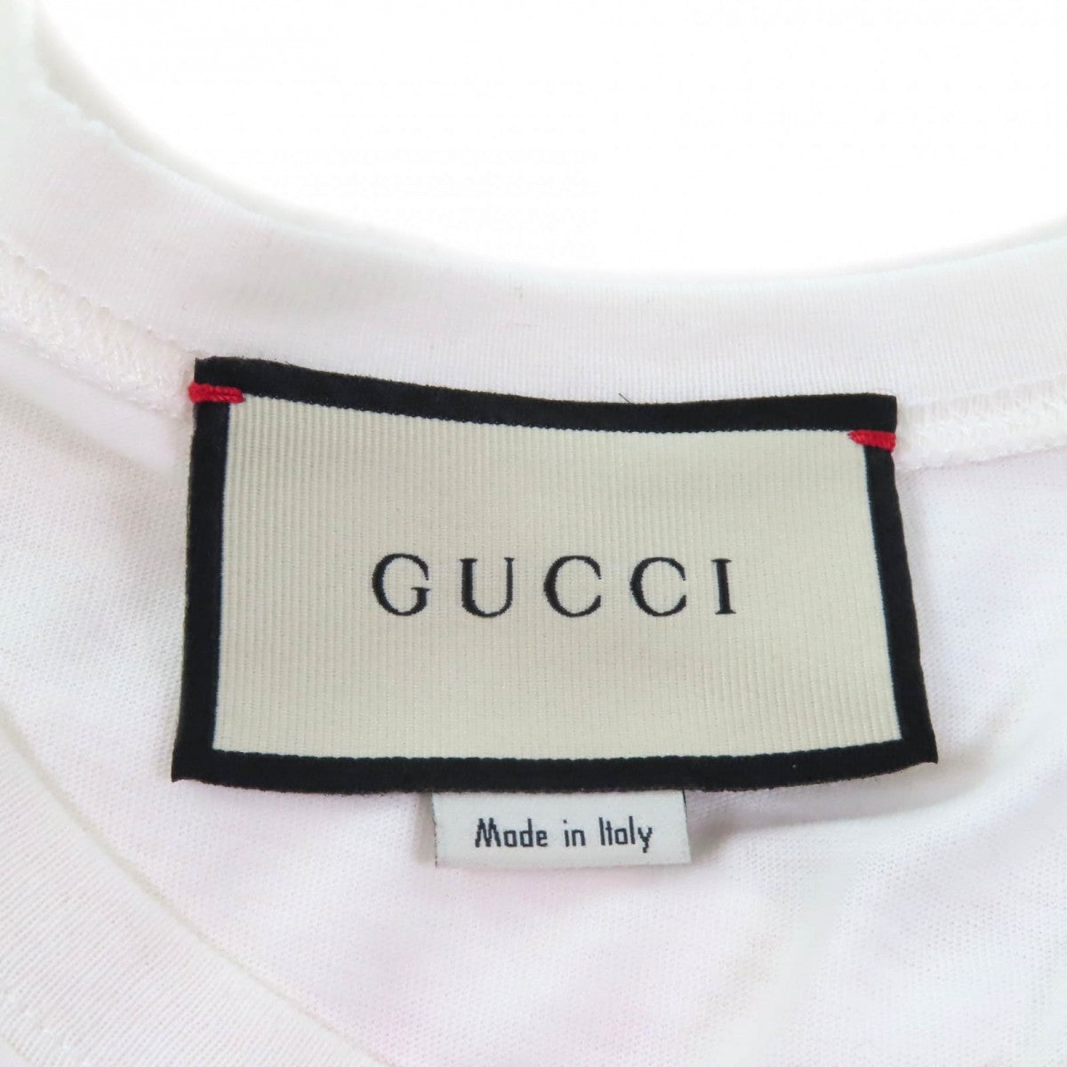 Label of a pre-owned Gucci t-shirt showcasing the brand name and Made in Italy detail