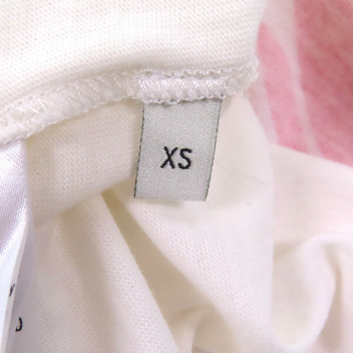 Close-up of a tag on a pre-owned Gucci t-shirt indicating size XS