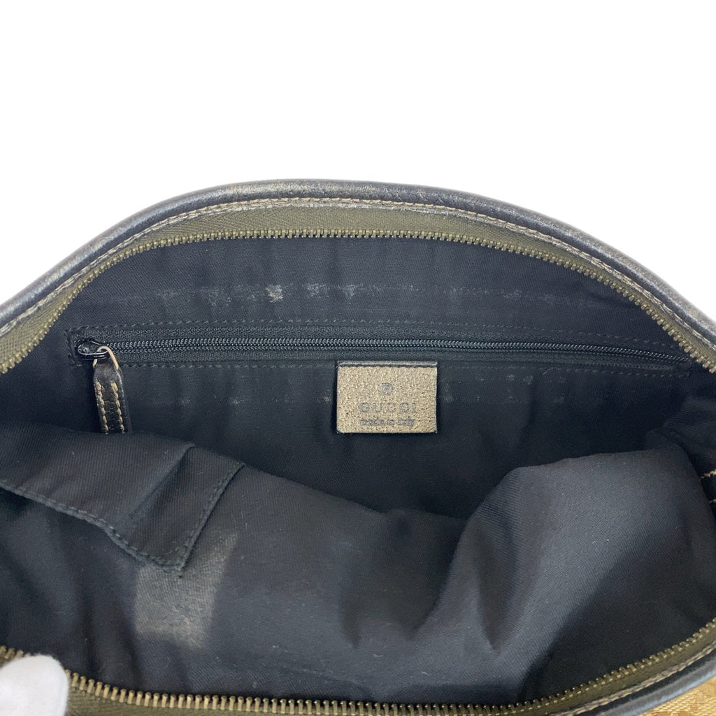 Interior view of a vintage GUCCI bag showcasing a spacious black compartment with a zipper pocket