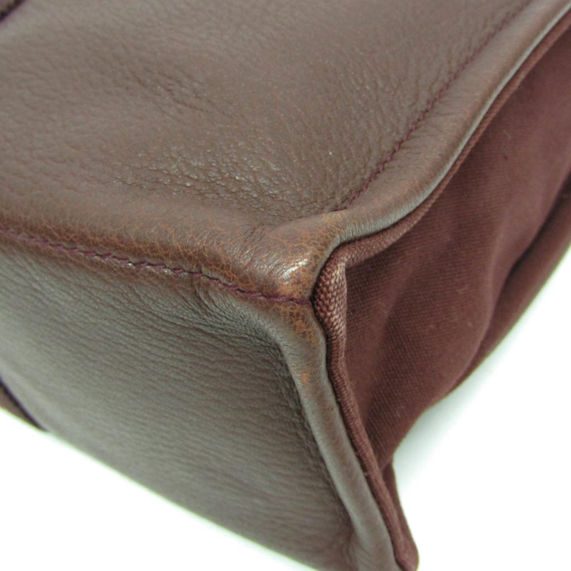 Close-up of HERMÈS Pre-Loved Fourre Tout MM tote bag in rich brown leather showcasing quality stitching
