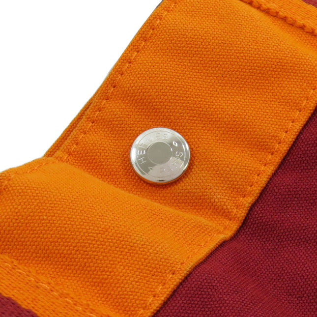 HERMES pre-owned bag detail featuring a silver button and vibrant color contrast