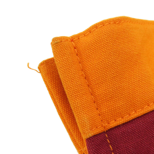 Close-up of a HERMES pre-owned bag featuring a vibrant orange and maroon fabric texture