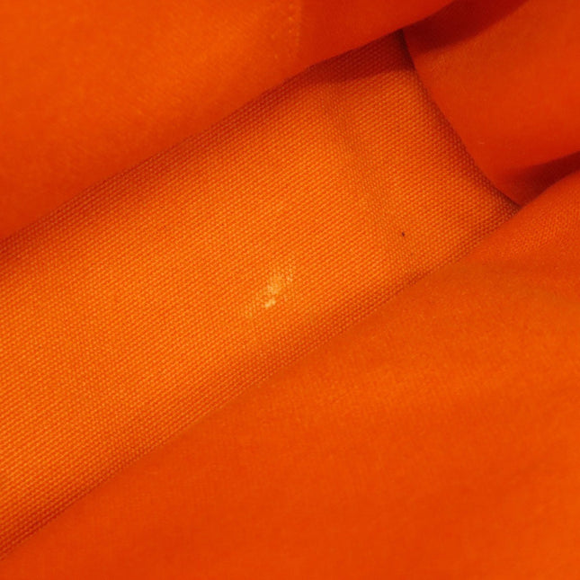 Close-up of the interior lining of a pre-owned Hermes bag in vibrant orange fabric