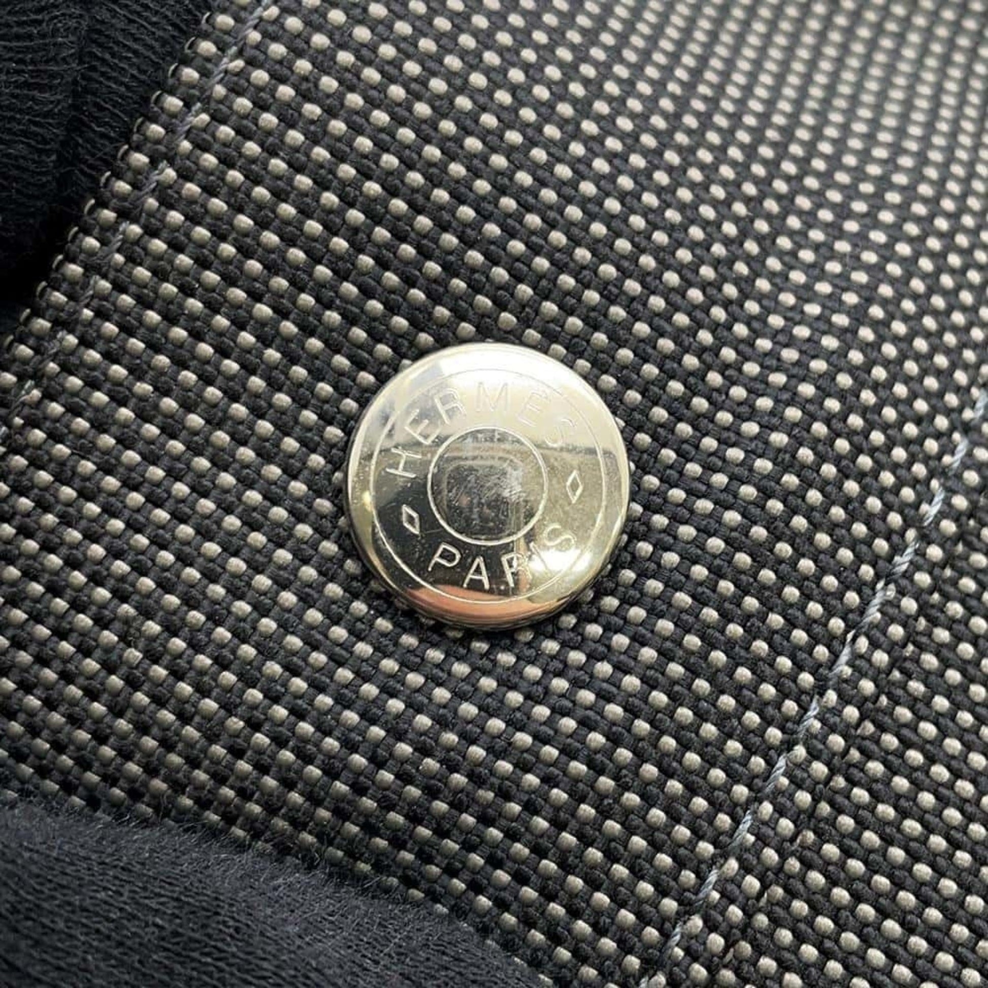Close-up of a pre-owned Hermes bag hardware featuring a silver logo button detail
