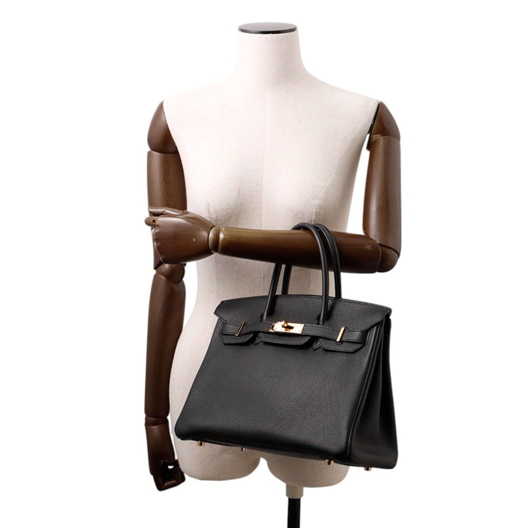 Pre-owned Hermès Birkin 30 handbag displayed on a mannequin with elegant black leather design