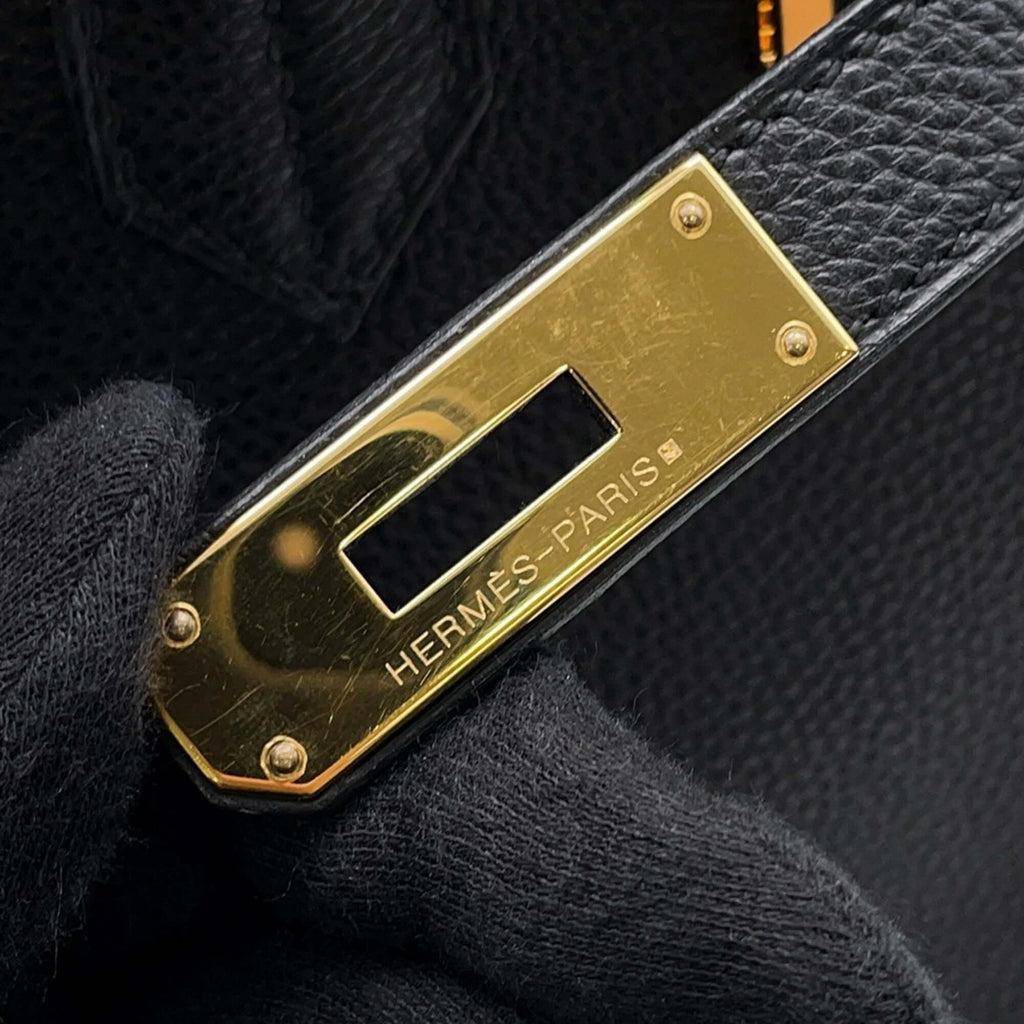 Close-up of the gold hardware on a pre-owned Hermès Birkin 30 handbag showcasing engraved logo details