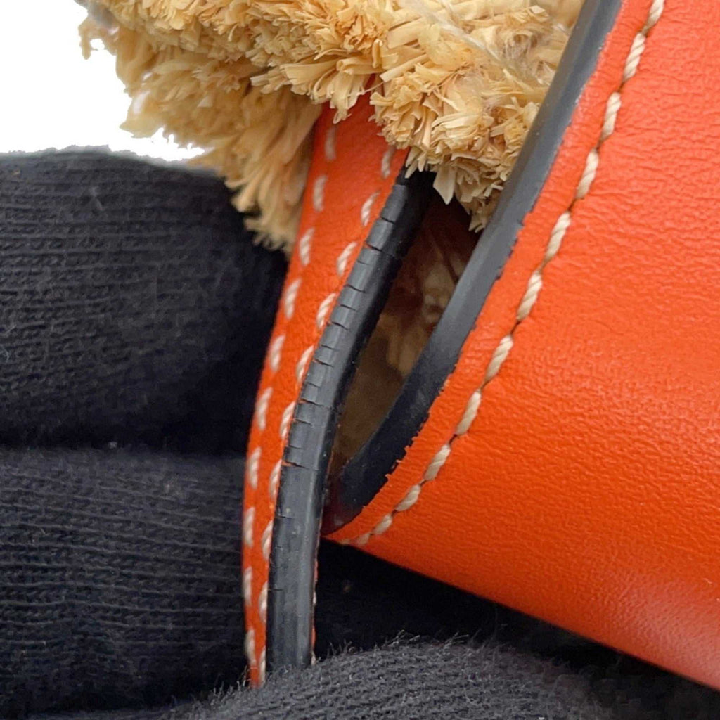 Close-up of the MANSII LOEWE Pre-Loved Gate Mini Raffia Bag showcasing its distinct orange leather and raffia details
