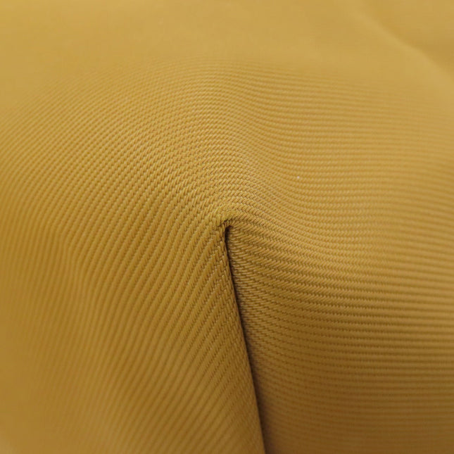 Close-up of a pre-owned Longchamp bag showing textured mustard fabric and stitching detail