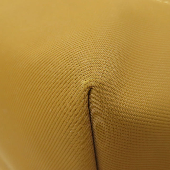 Close-up of a yellow Longchamp bag featuring a textured surface, pre-owned condition