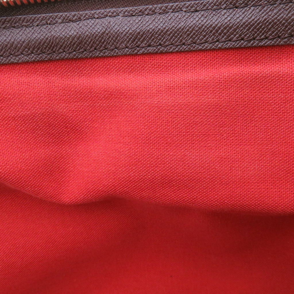 Interior view of authentic Louis Vuitton Belem MM bag for sale showcasing red lining and quality stitching