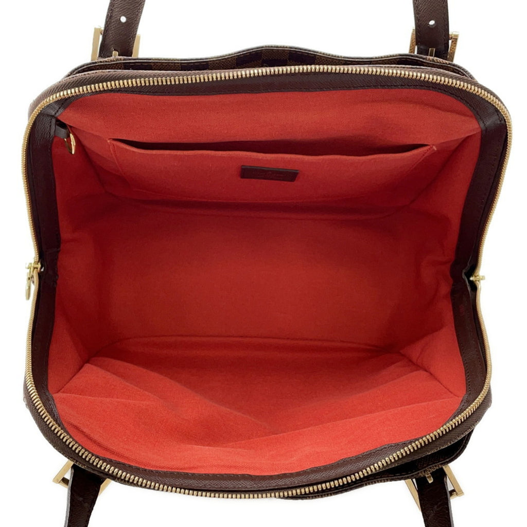 Interior view of authentic Louis Vuitton Belem MM bag for sale featuring a spacious red lining