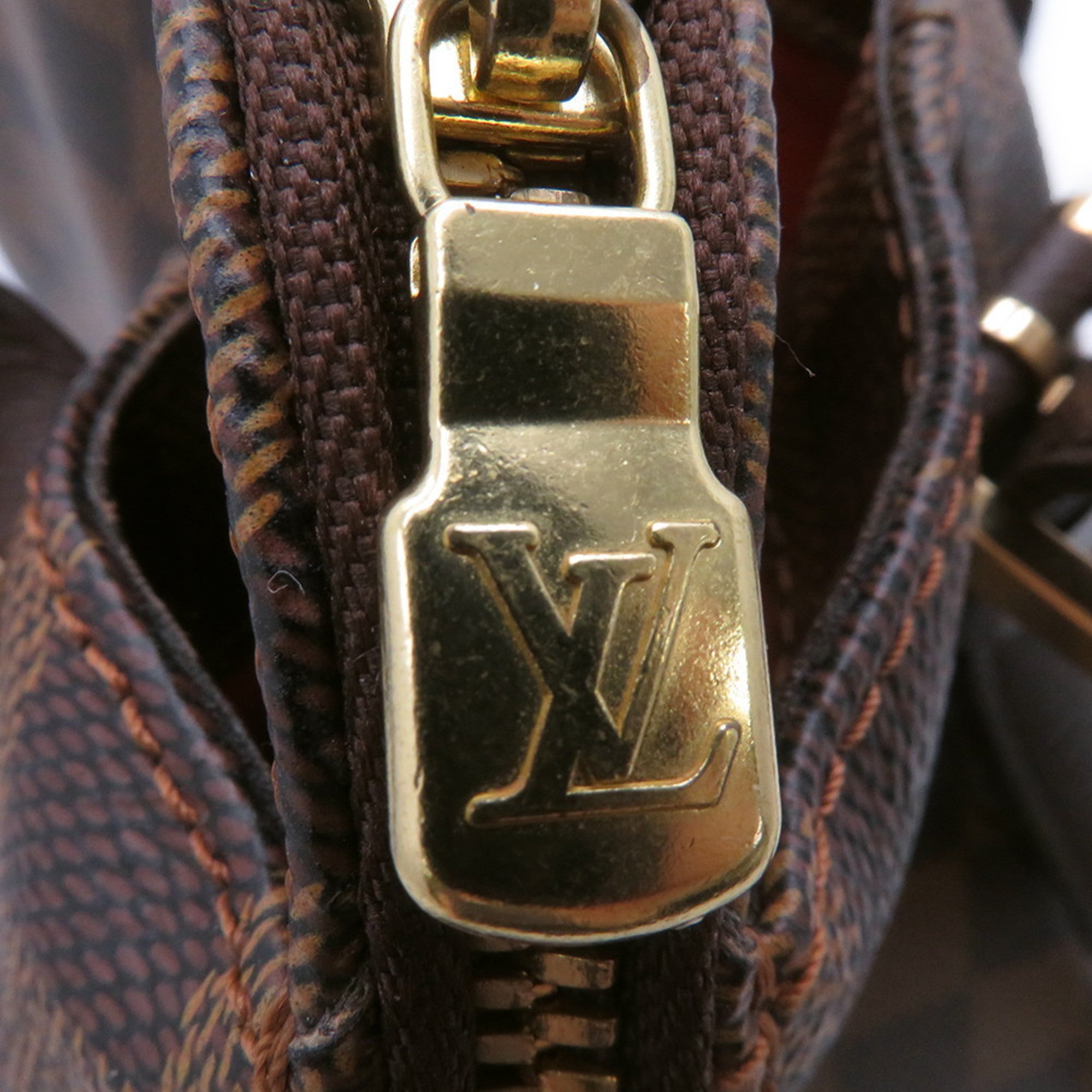 Close-up of the zipper detail on an authentic Louis Vuitton Belem MM bag for sale showcasing the iconic LV logo