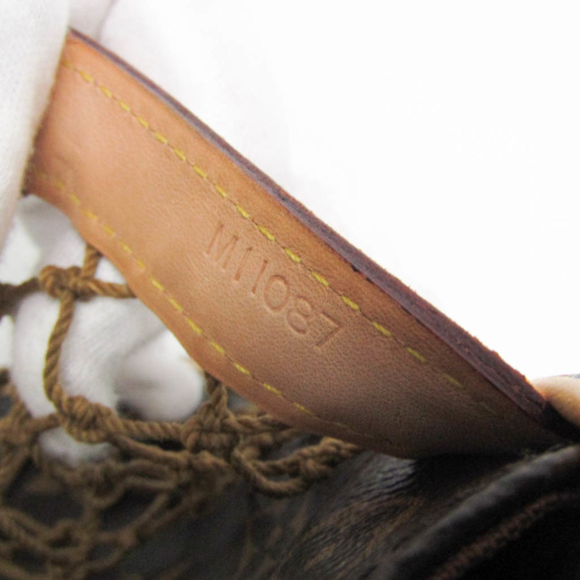 Close-up of the interior tag on a LOUIS VUITTON pre-loved Congo PM bag showing serial number details