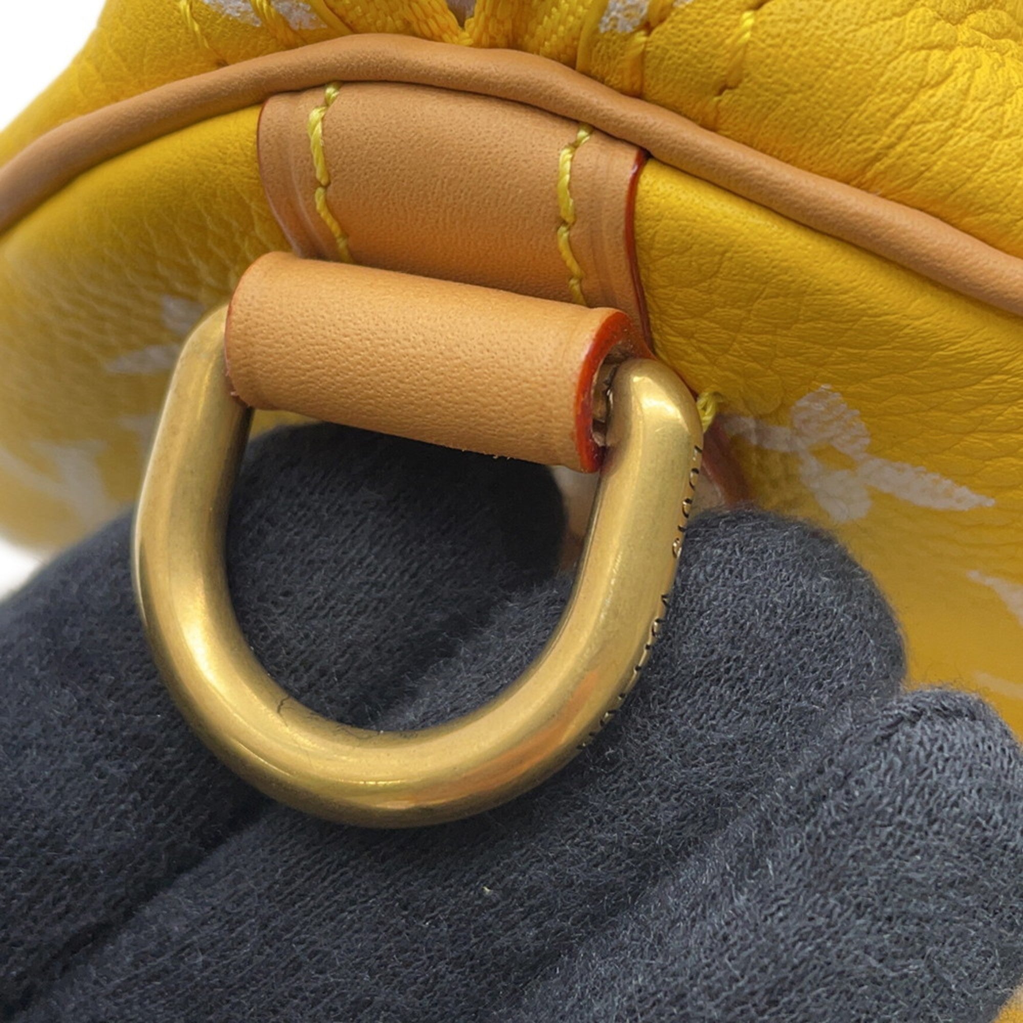Close-up of a pre-loved MANSII handbag featuring a gold D-ring and vibrant yellow leather.