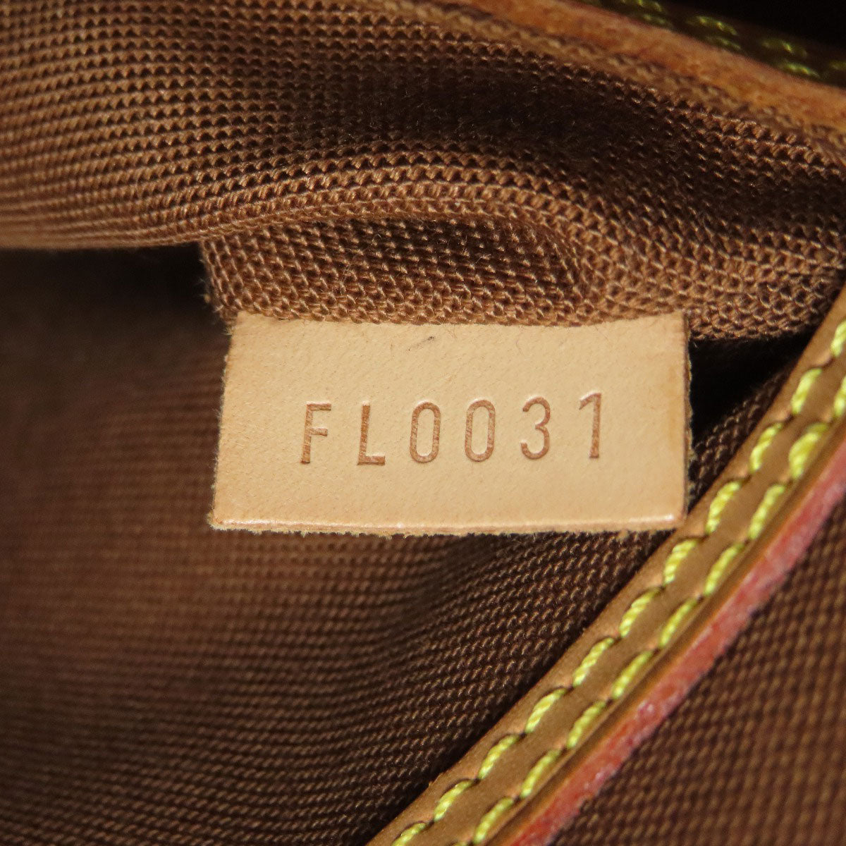 Interior tag of a LOUIS VUITTON pre-owned bag showing the serial number FL0031