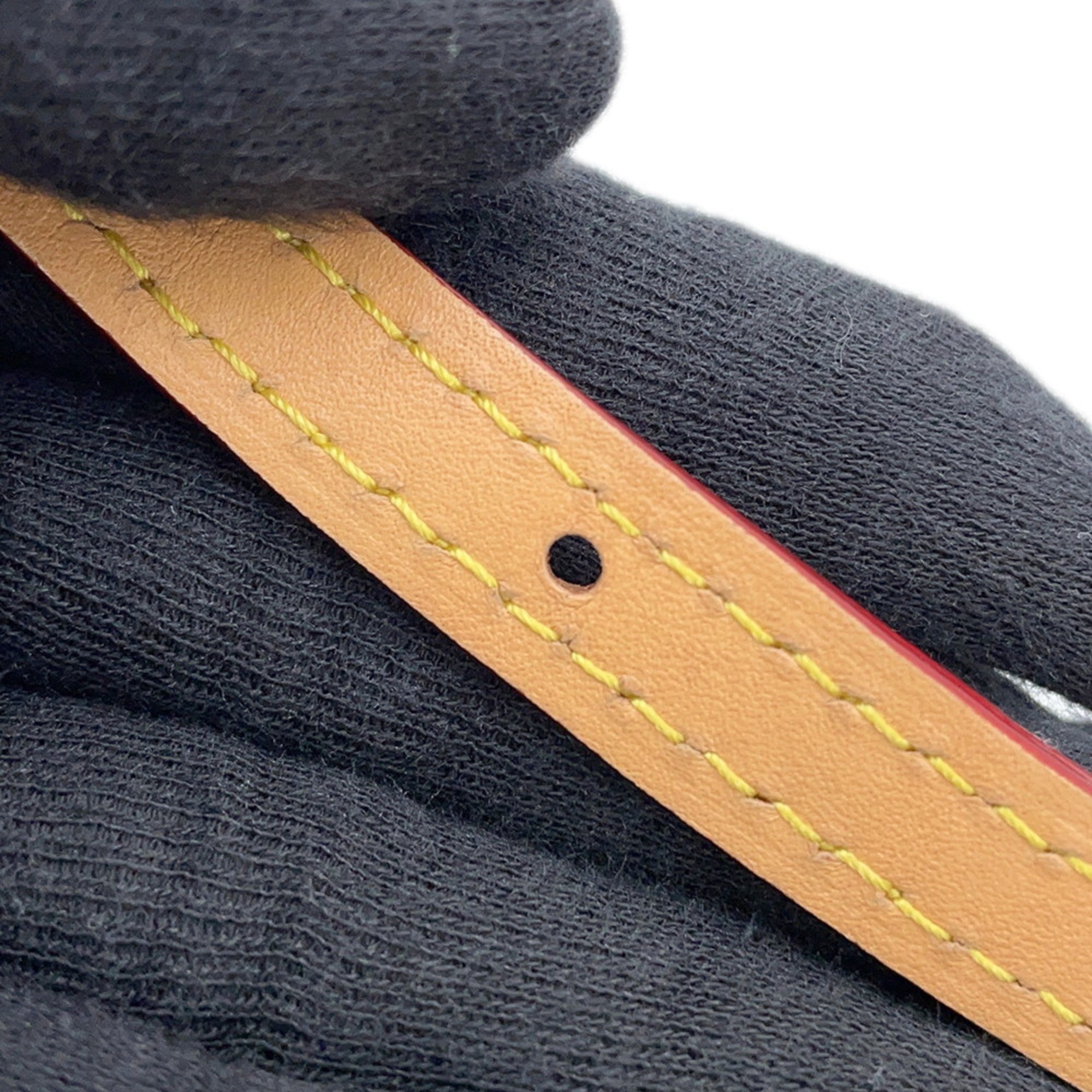 Close-up of the strap detailing on a pre-owned Louis Vuitton Chantilly bag showcasing stitching and hole design