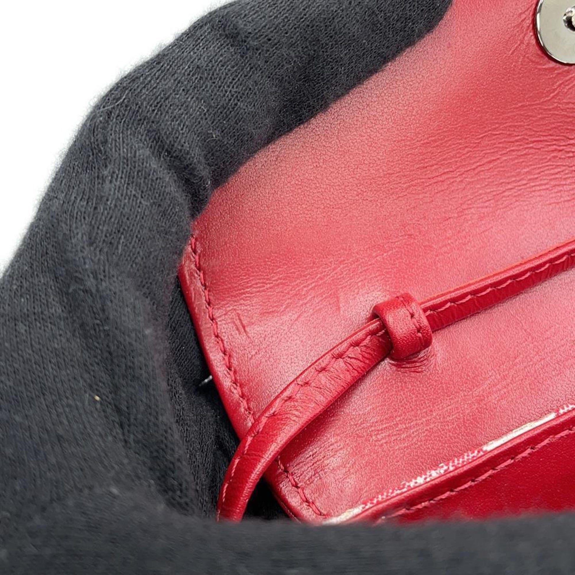 Inside view of a Louis Vuitton bag showcasing pre-owned red leather lining and secure closure