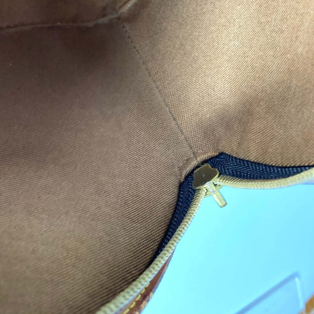 Interior view of a pre-owned Louis Vuitton bag showing the zipper and lining details