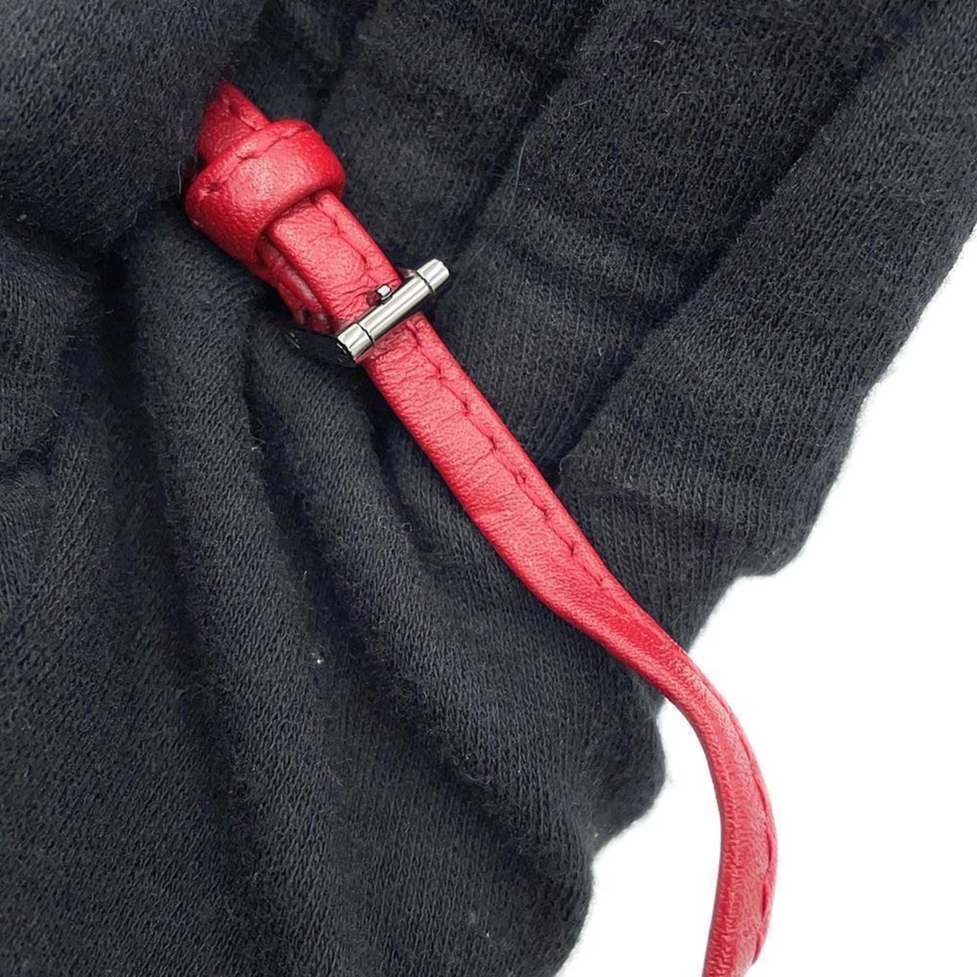 Close-up of Louis Vuitton bag strap in red leather, showcasing pre-owned condition details